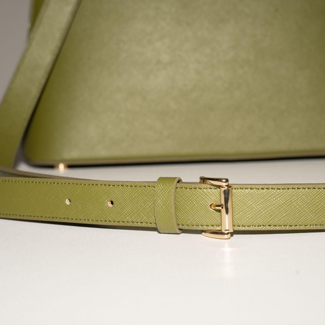 A close-up of the adjustable strap on Ms. Lady Luck in Olive Green. The finely stitched cactus leather strap and polished gold buckle offer both durability and style.