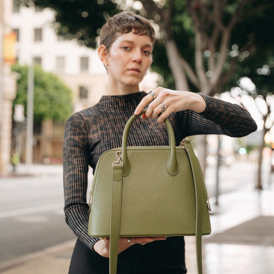 Ms. Lady Luck handbag in olive green cactus leather, featuring gold-tone hardware and a structured silhouette, elegantly displayed.