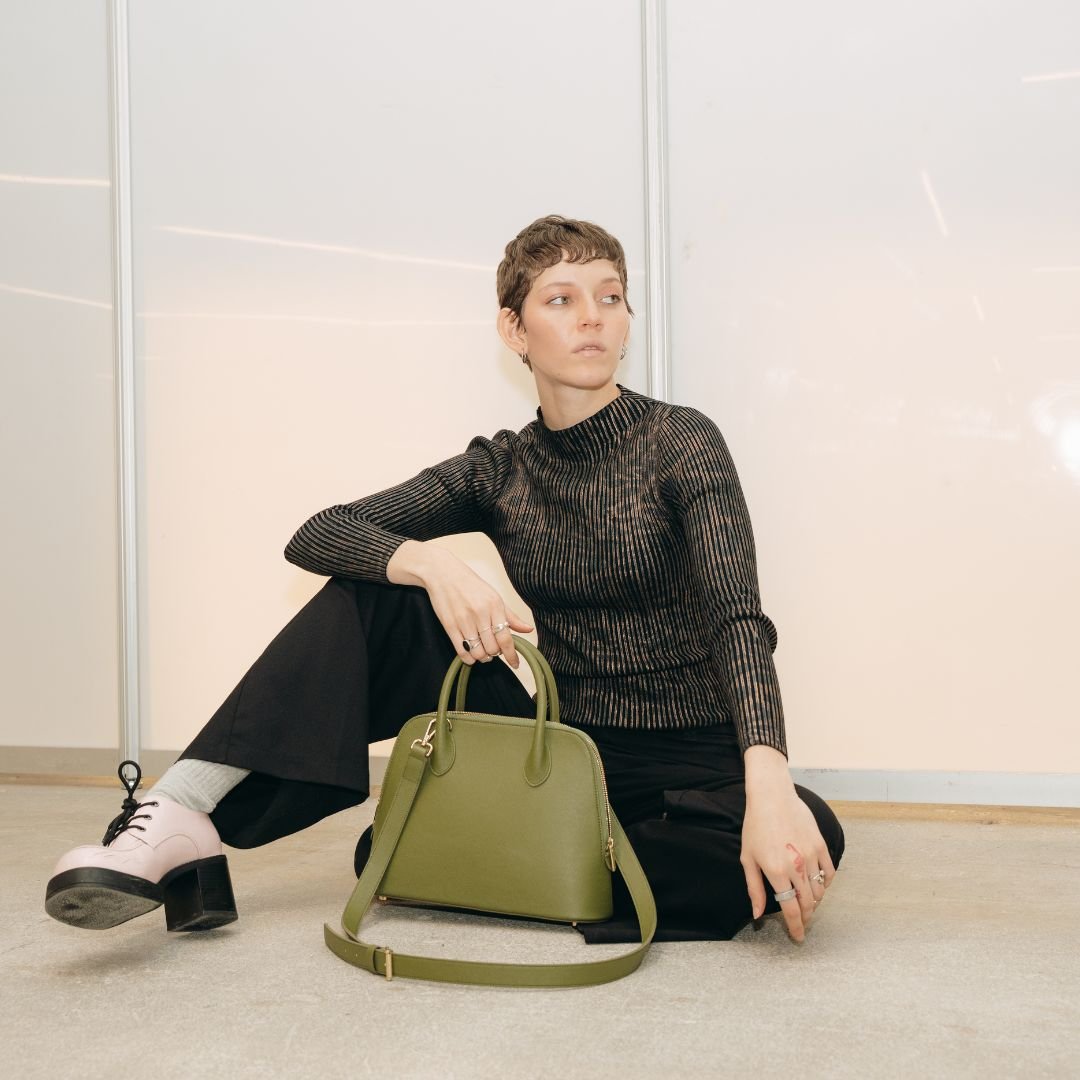 A model holding the Ms. Lady Luck handbag, demonstrating its timeless style and practical design.