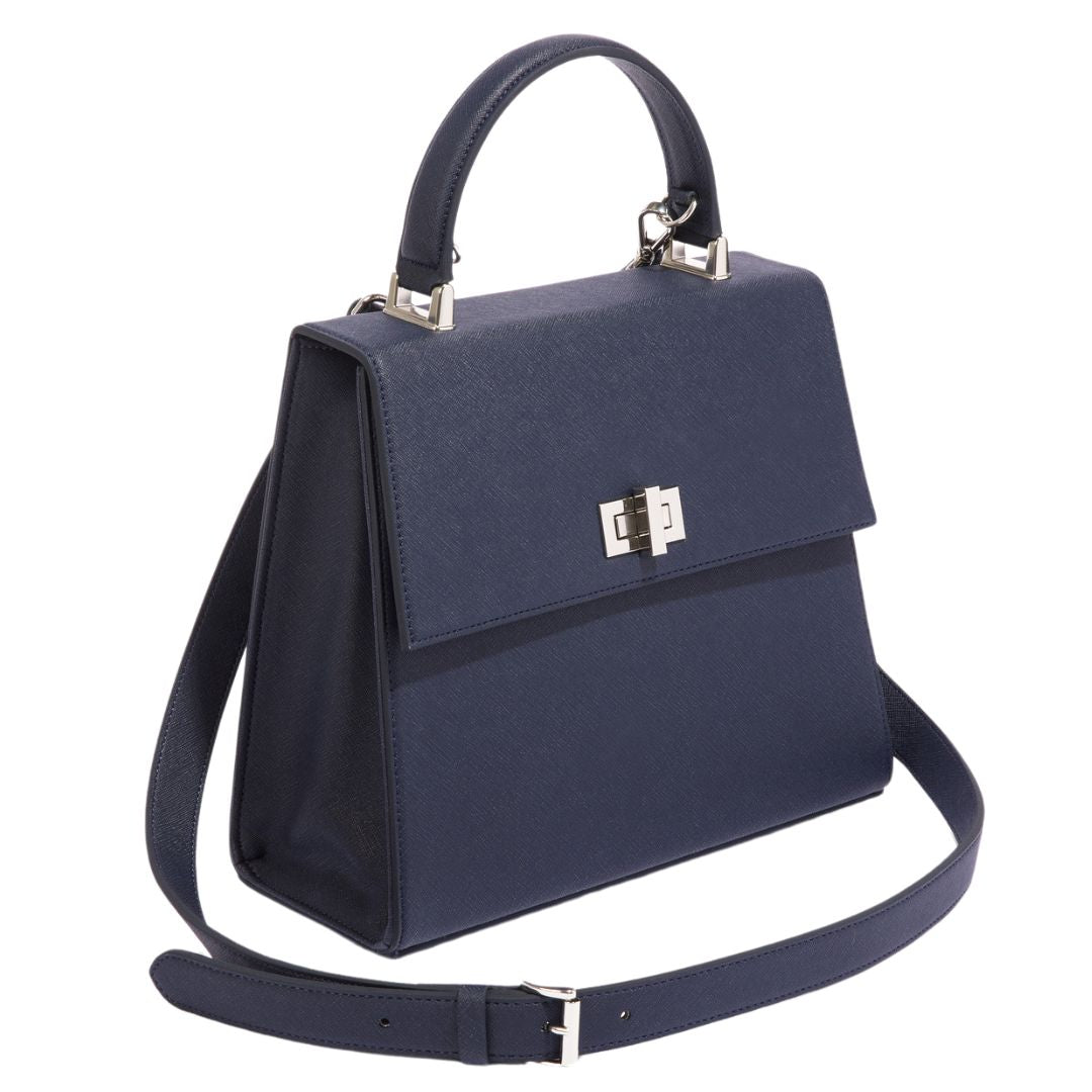 An angled view of The She-EO handbag in navy blue cactus leather, emphasizing its modern shape, premium vegan leather, and detachable crossbody strap. A perfect blend of functionality and sustainable fashion