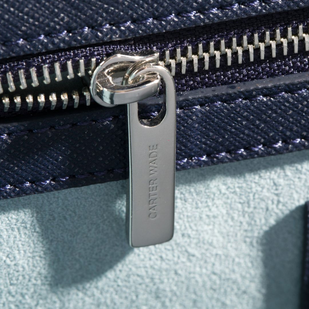A close-up of the Carter Wade-branded silver zipper on The She-EO handbag, seamlessly integrated into the navy blue cactus leather design. Ethically made with high-quality craftsmanship