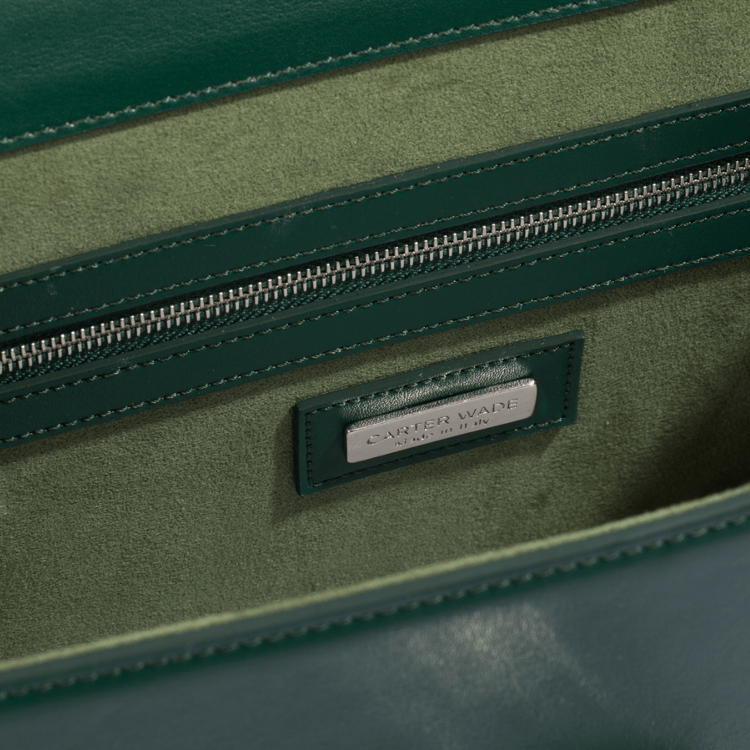 The interior of the Ms. Lady Luck handbag, featuring a soft, suede-like green lining with a zippered pocket and a silver-toned Carter Wade nameplate. The fine stitching and premium material emphasize the bag’s high-quality craftsmanship.